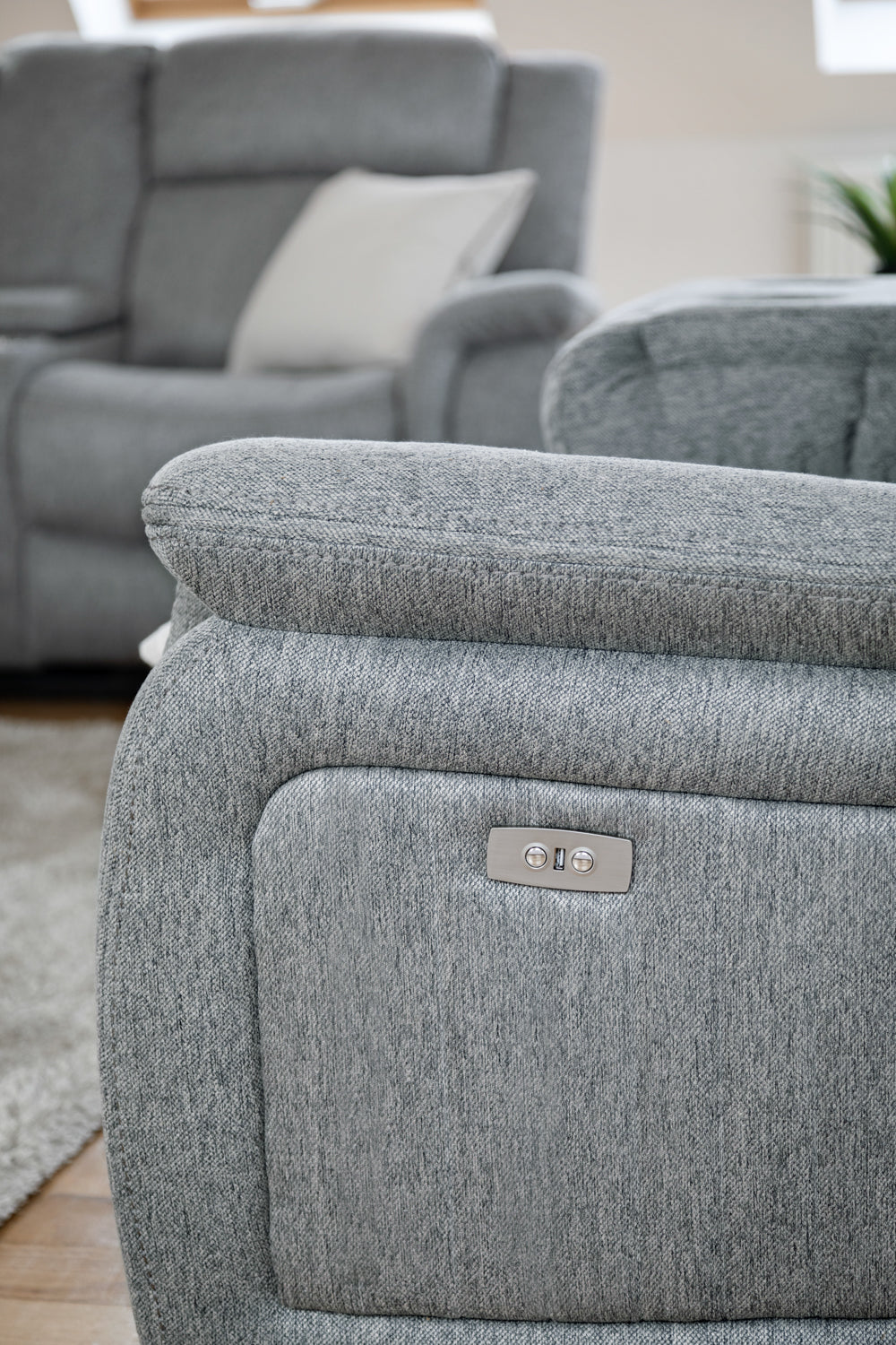 Gray recliner chair with a visible brand logo in a living room setting.