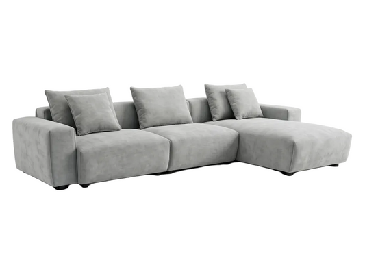 Gray sectional sofa in a living room with large windows and a white rug.