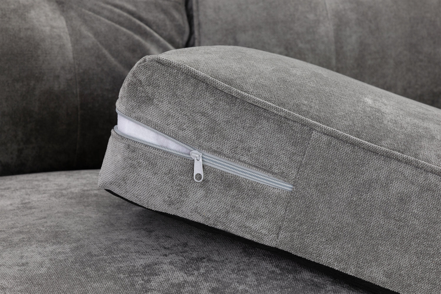 Gray sofa with a cushion featuring a zipper detail
