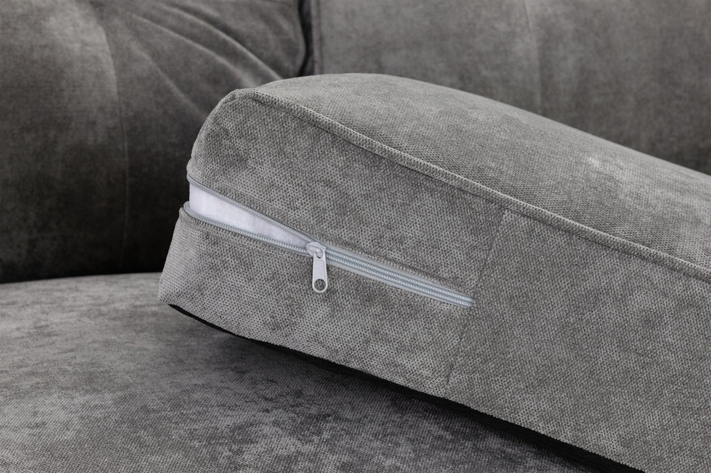 Gray sofa with a cushion featuring a zipper detail