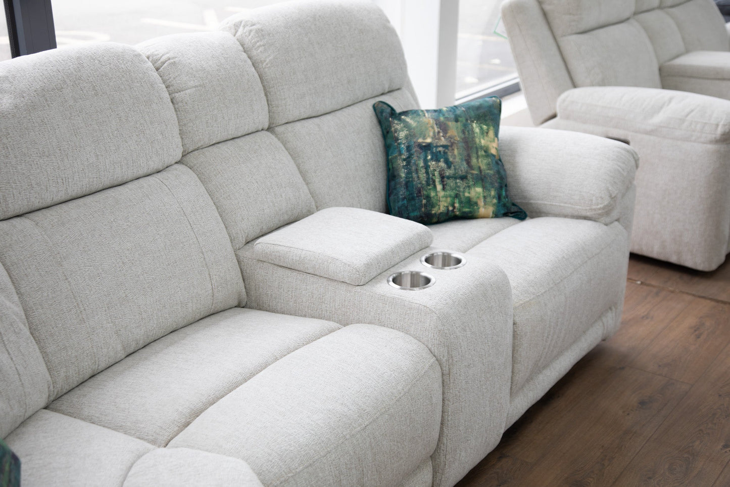 Beige sectional sofa with a decorative pillow on a wooden floor