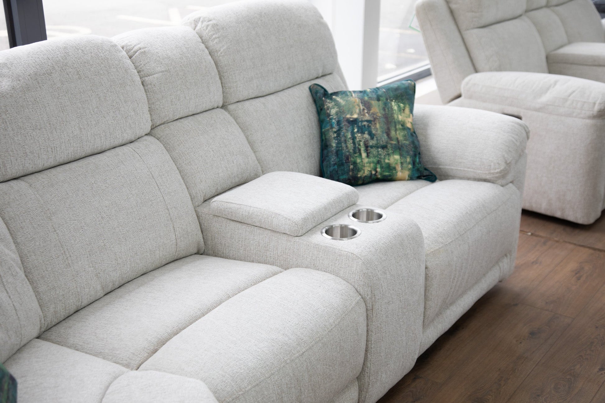 Beige sectional sofa with a decorative pillow on a wooden floor