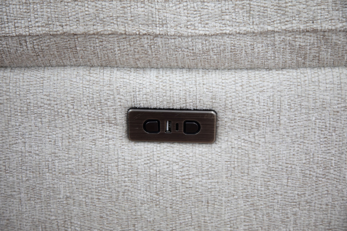 Close-up of a textured beige surface with a small metallic switch.