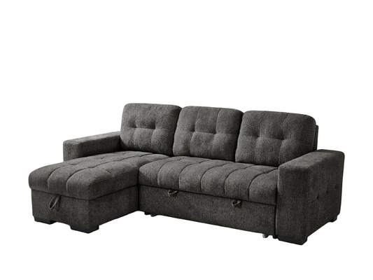 A dark gray tufted fabric sectional sofa with a chaise lounge on the left, shown against a plain white background.