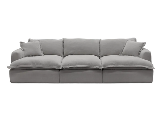 Gray sectional sofa in a living room with a round rug and a lamp.