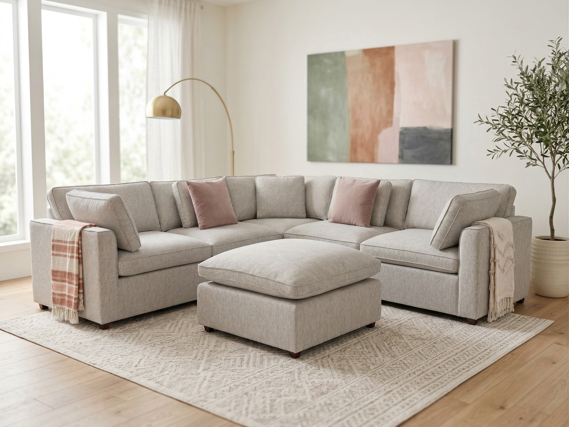 Light gray sectional sofa in a living room with a abstract painting on the wall.
