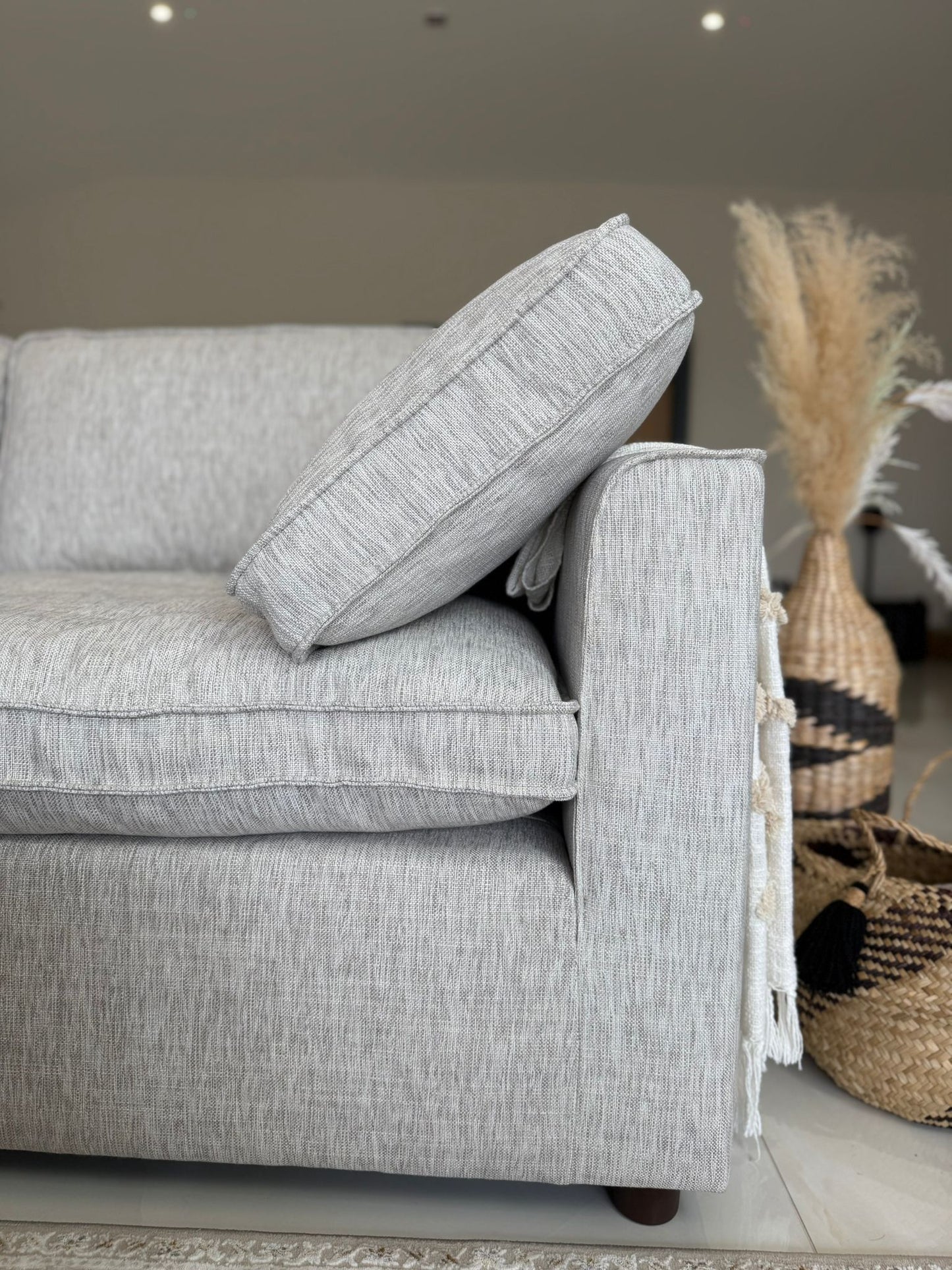 Gray sofa with a textured pillow in a living room setting