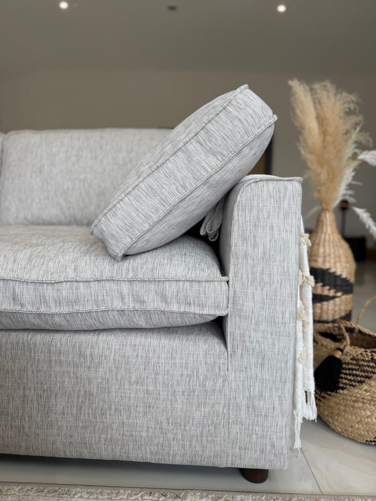 Gray sofa with a textured pillow in a living room setting