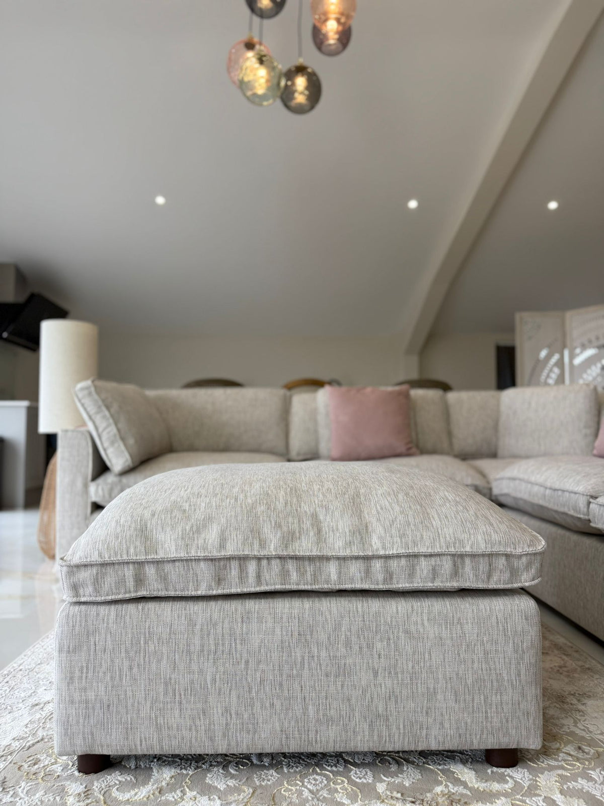 Gray sectional sofa with pink pillow in a modern living room