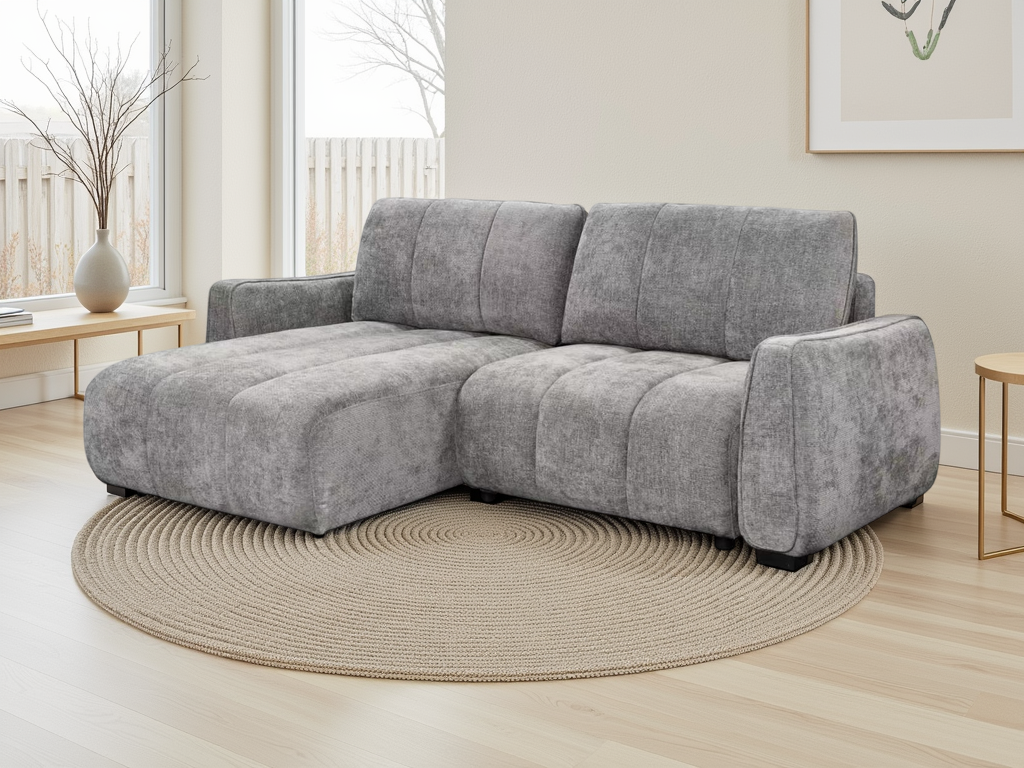 A modern grey fabric sectional sofa with a chaise lounge, styled in a bright living room on a round woven rug.