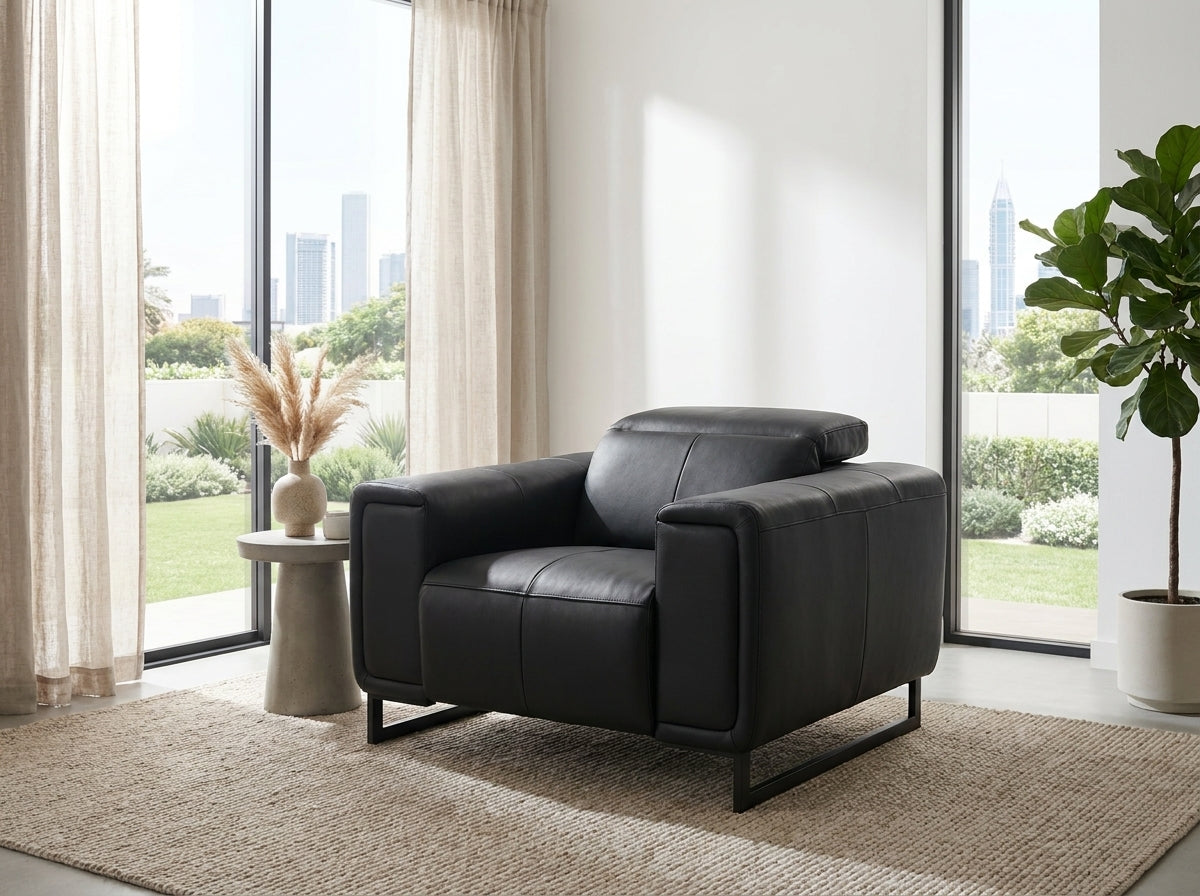 A modern black leather armchair with a low black metal frame.