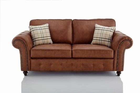 Brown leather sofa with plaid cushions on a white background