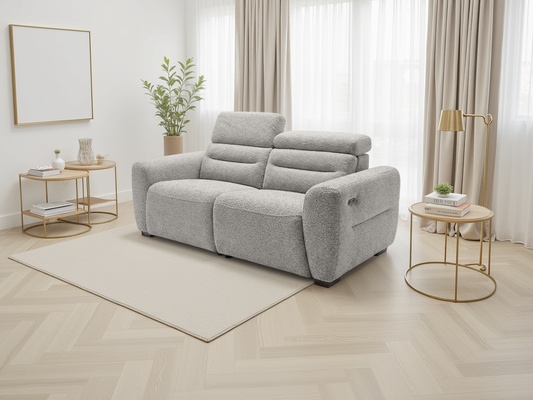 Gray sofa in a modern living room with gold side tables and white curtains.