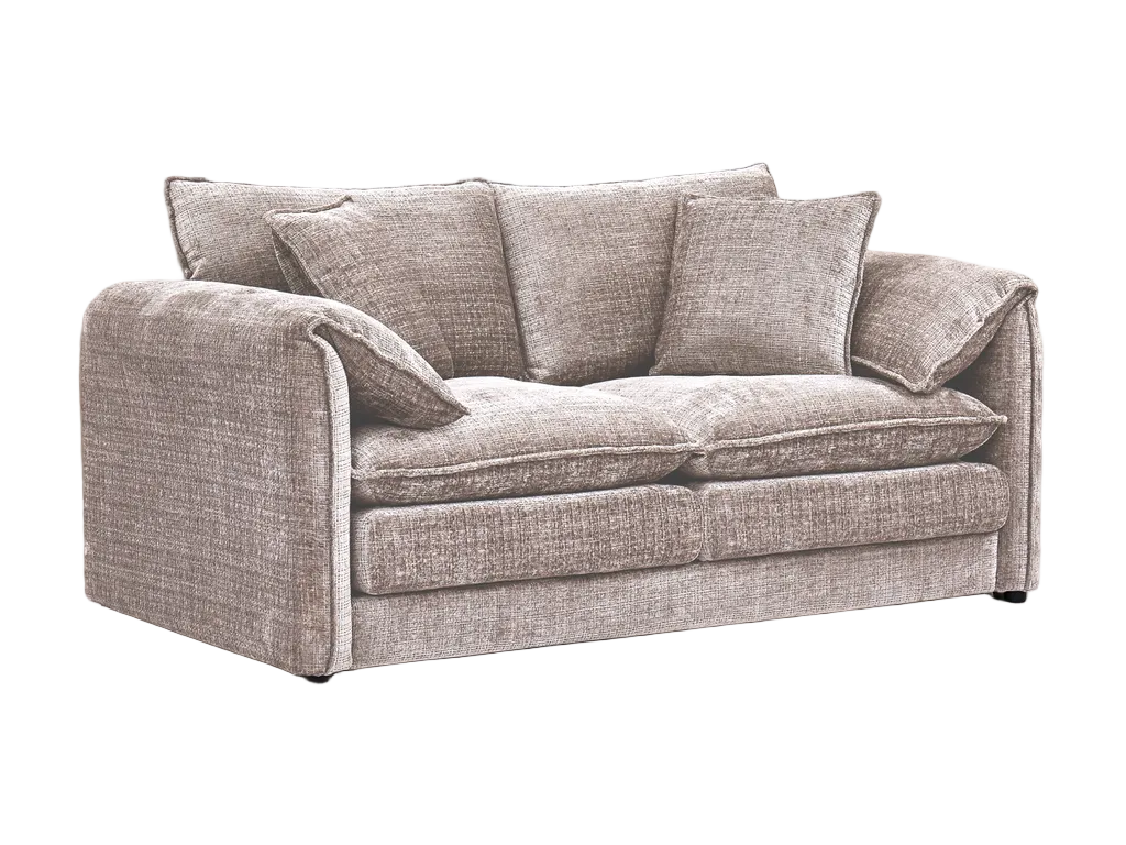 Beige sofa in a living room with a patterned rug and framed pictures on the wall.