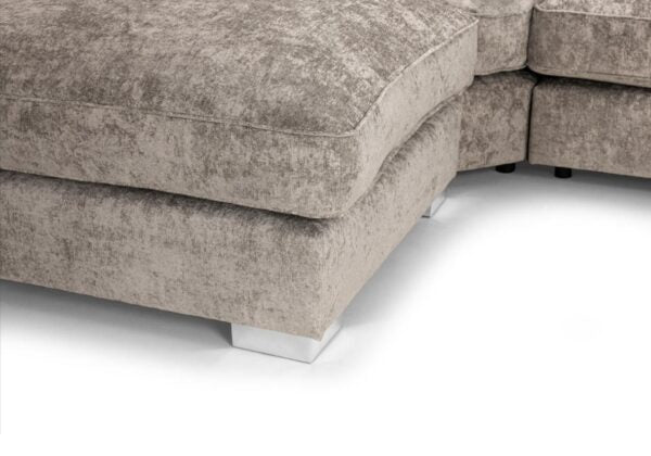 Close-up of a textured light gray upholstered sectional sofa corner with a white floor visible.